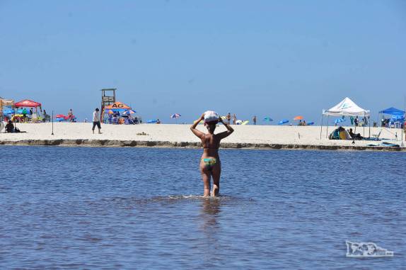 A Ana atravessa a lagoa em direção à praia na Guarda do Embaú, litoral sul de Santa Catarina
